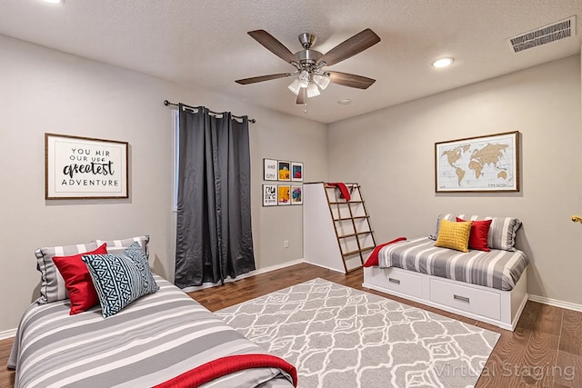 bedroom featuring wood finished floors, a textured ceiling, baseboards, visible vents, and recessed lighting