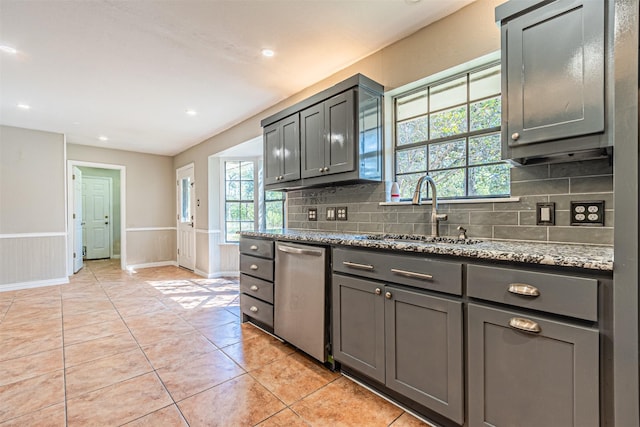 kitchen featuring light tile patterned flooring, sink, gray cabinetry, light stone countertops, and decorative backsplash