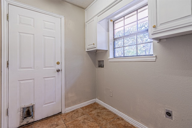 laundry room with hookup for a washing machine, hookup for an electric dryer, light tile patterned floors, and cabinets