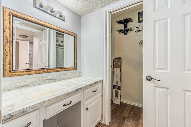 bathroom with wood finished floors, vanity, and a textured ceiling