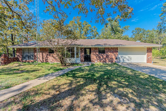 single story home featuring driveway, a front yard, a garage, and brick siding