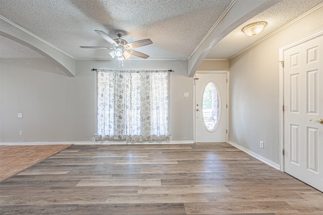 entrance foyer featuring ornamental molding, hardwood / wood-style floors, and a textured ceiling