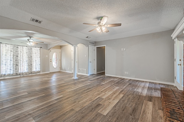 unfurnished living room with ceiling fan, decorative columns, hardwood / wood-style flooring, and a textured ceiling