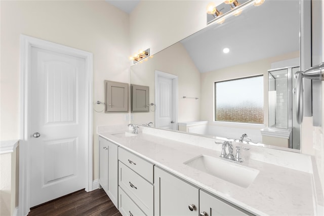 bathroom featuring walk in shower, vaulted ceiling, vanity, and hardwood / wood-style floors