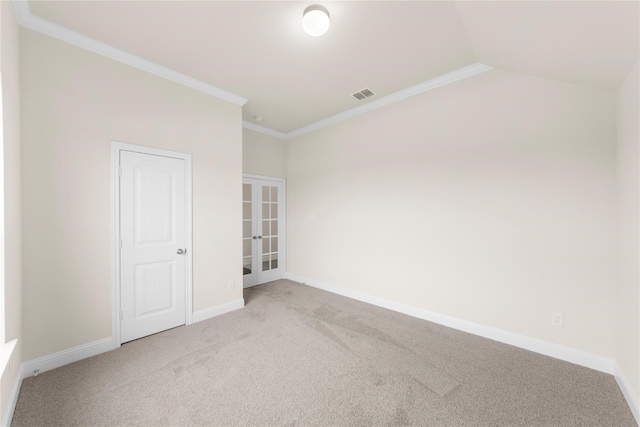 carpeted empty room featuring ornamental molding and vaulted ceiling