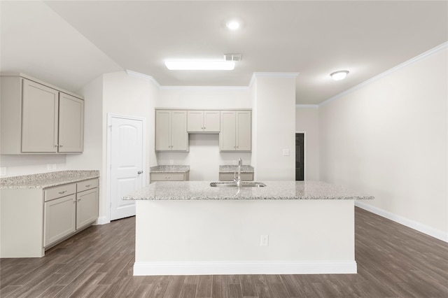 kitchen with dark wood-type flooring, gray cabinets, a kitchen island with sink, and light stone counters