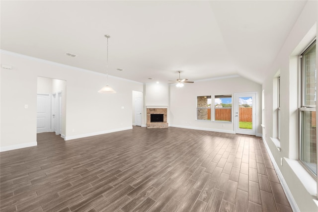 unfurnished living room with ceiling fan, lofted ceiling, a brick fireplace, dark hardwood / wood-style floors, and crown molding