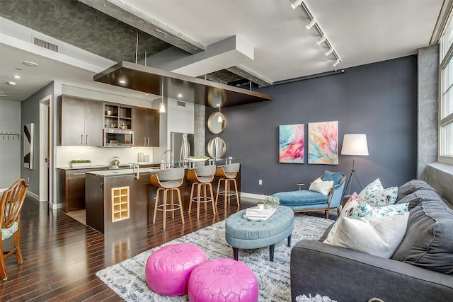 living room featuring dark wood-type flooring and rail lighting