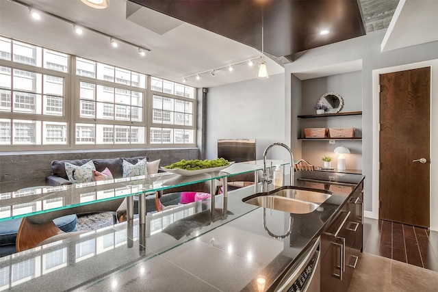 kitchen with dark stone counters, sink, breakfast area, and track lighting