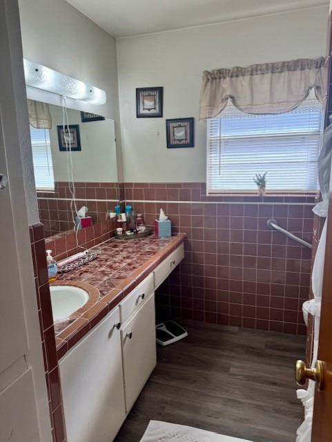 bathroom featuring hardwood / wood-style flooring, tile walls, and vanity