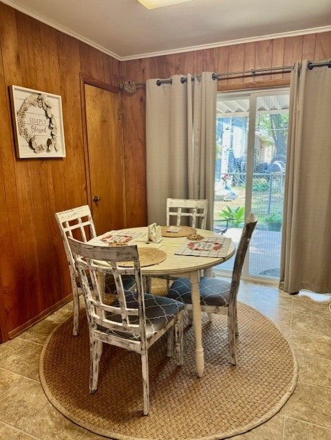 dining area featuring wooden walls, crown molding, and tile patterned floors