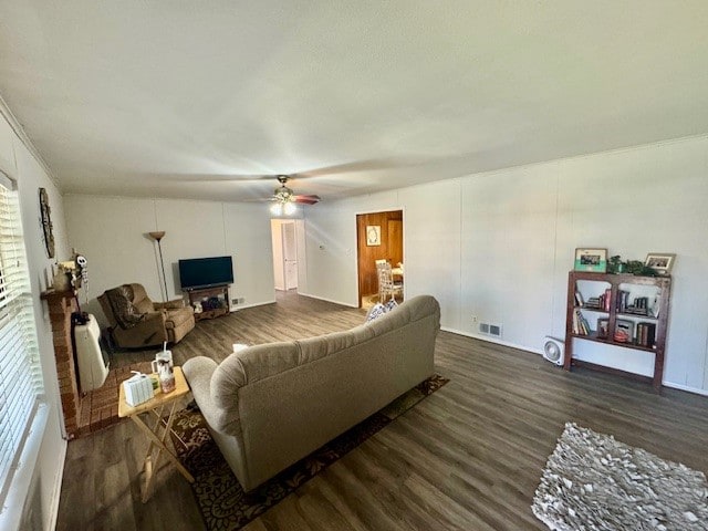 living room featuring dark wood-type flooring and ceiling fan