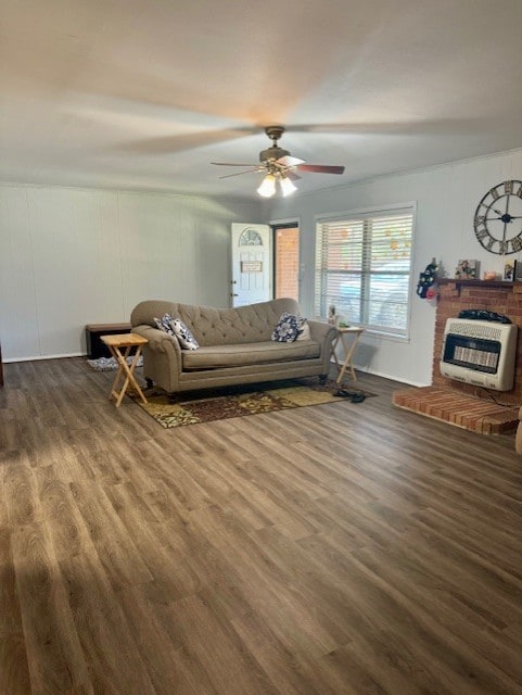 living room with ceiling fan, heating unit, a fireplace, and dark hardwood / wood-style flooring