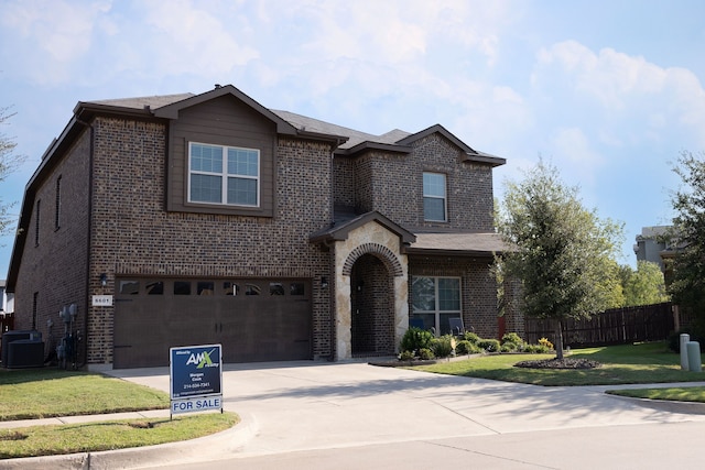 view of front of property with a garage, cooling unit, and a front lawn