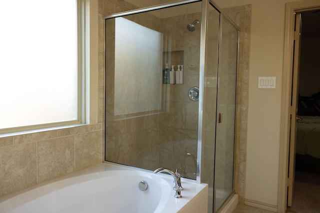 bathroom featuring shower with separate bathtub