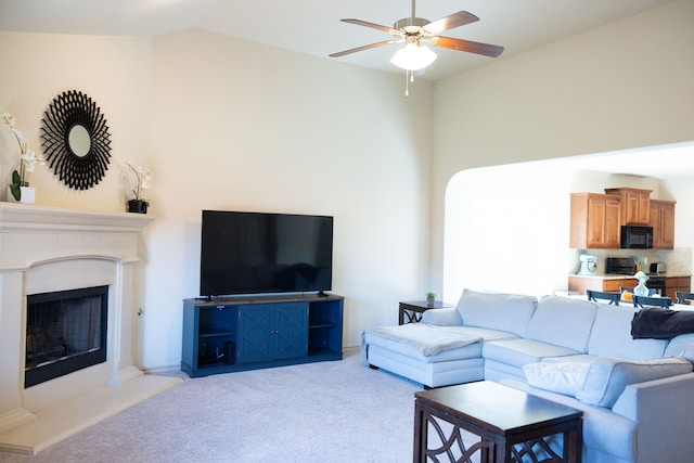 living room featuring light carpet, ceiling fan, and vaulted ceiling