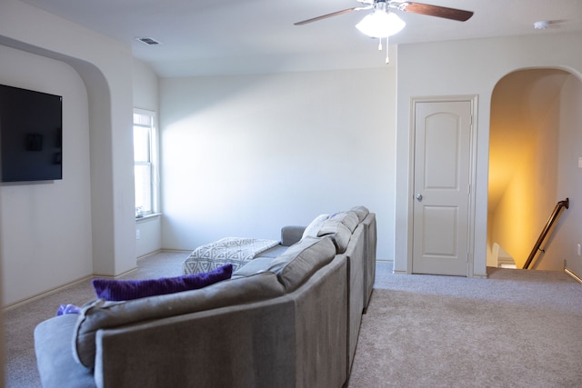 carpeted living room with ceiling fan