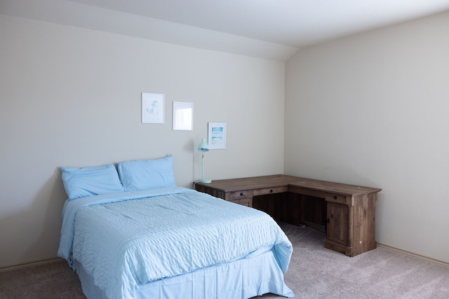 bedroom with vaulted ceiling and light colored carpet