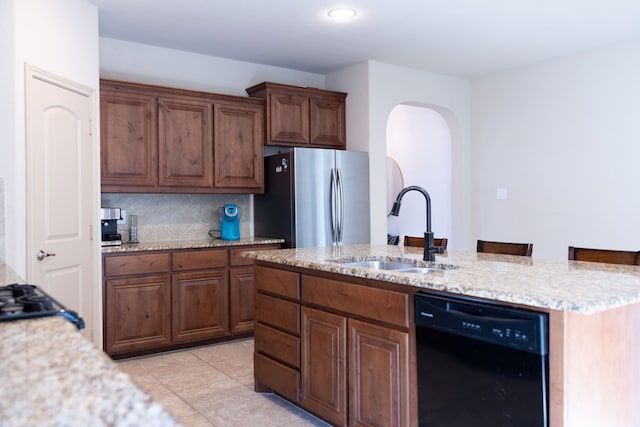 kitchen with stainless steel fridge, sink, backsplash, dishwasher, and a kitchen bar