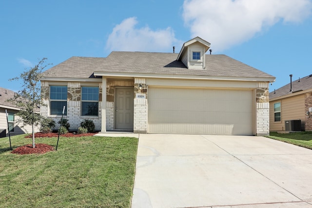 view of front of house featuring a front lawn, central air condition unit, and a garage