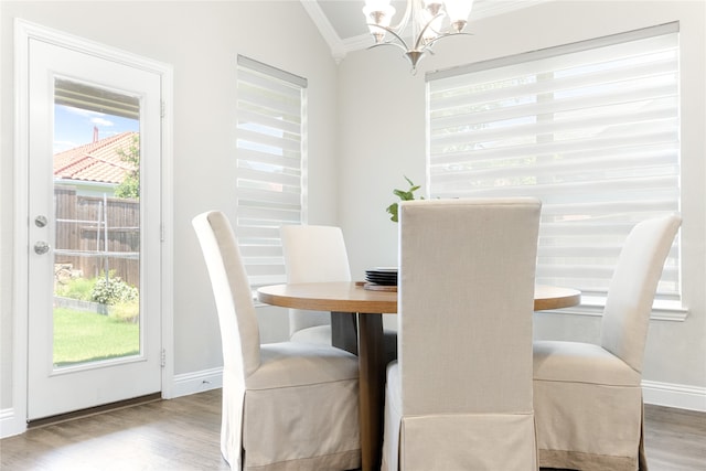 dining room featuring ornamental molding, vaulted ceiling, and hardwood / wood-style flooring