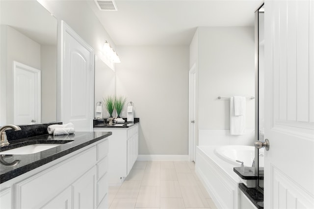 bathroom with vanity, a bathtub, and tile patterned flooring