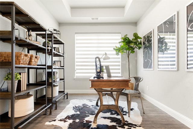 office featuring a tray ceiling and hardwood / wood-style floors