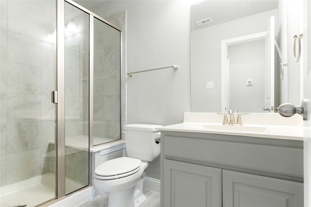 bathroom featuring a shower with door, vanity, and toilet