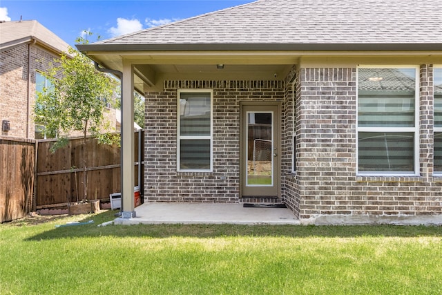 view of exterior entry featuring a lawn