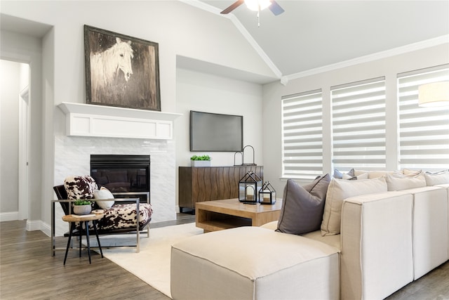 living room featuring wood-type flooring, a premium fireplace, crown molding, and vaulted ceiling