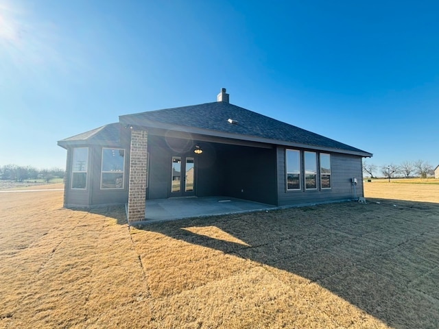 rear view of house featuring french doors, a yard, and a patio area