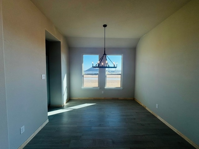 unfurnished dining area with a notable chandelier and dark hardwood / wood-style floors