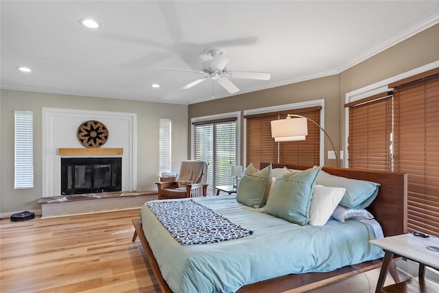 bedroom with hardwood / wood-style flooring, crown molding, and ceiling fan