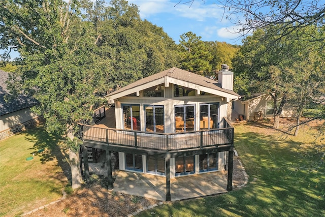 rear view of property featuring a wooden deck, a yard, and a patio