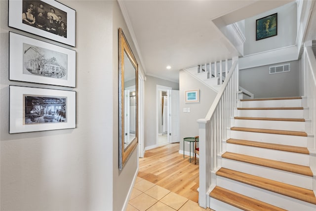 stairs featuring crown molding and wood-type flooring