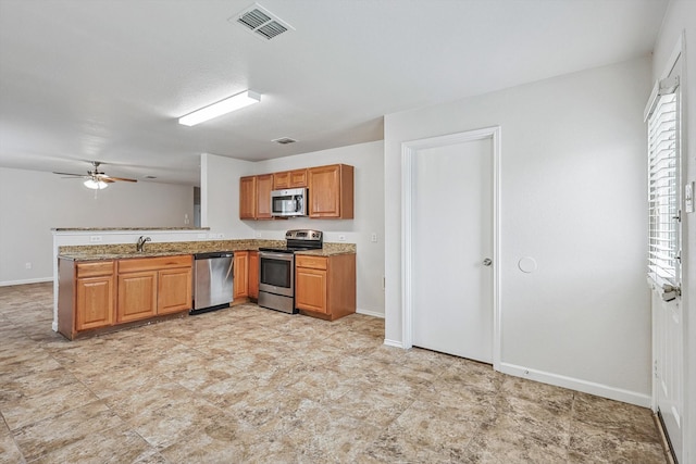 kitchen featuring kitchen peninsula, light stone counters, ceiling fan, and stainless steel appliances