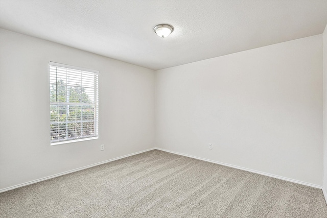 carpeted spare room featuring a textured ceiling