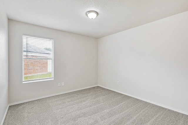 carpeted spare room featuring a textured ceiling