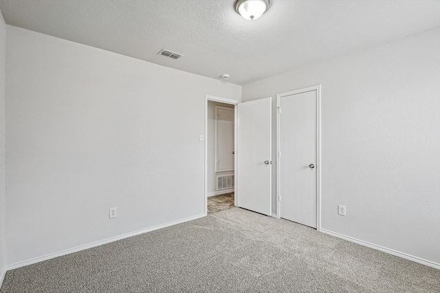 unfurnished bedroom with light carpet and a textured ceiling