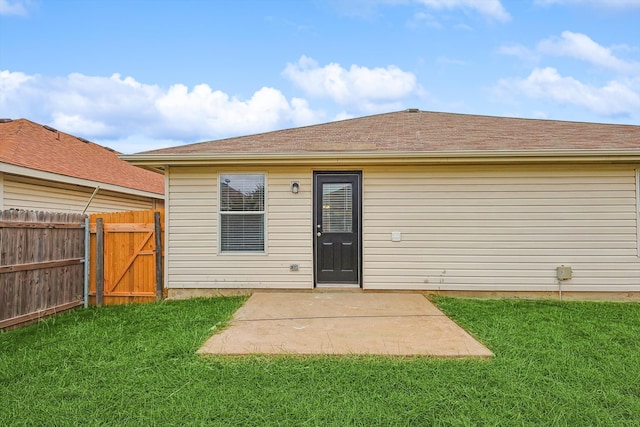 rear view of house with a yard and a patio area