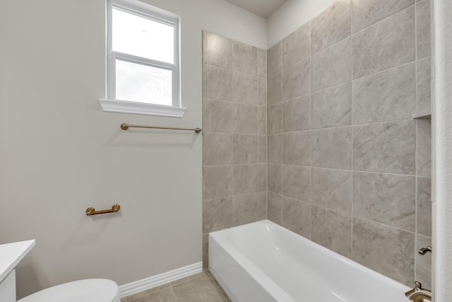 bathroom with tile patterned floors, toilet, and tiled shower / bath