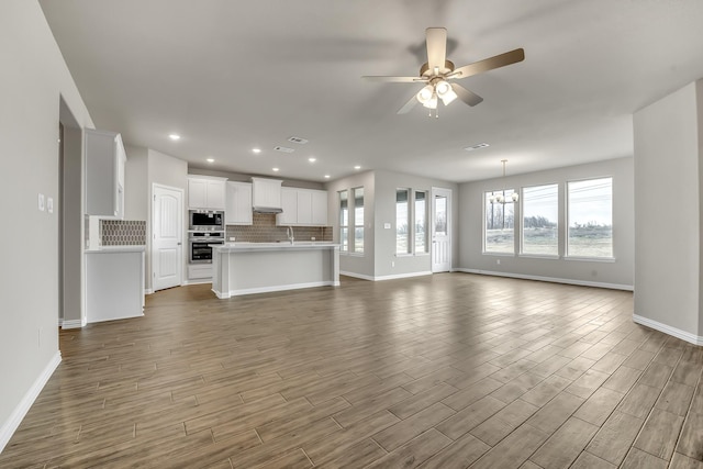 unfurnished living room with ceiling fan