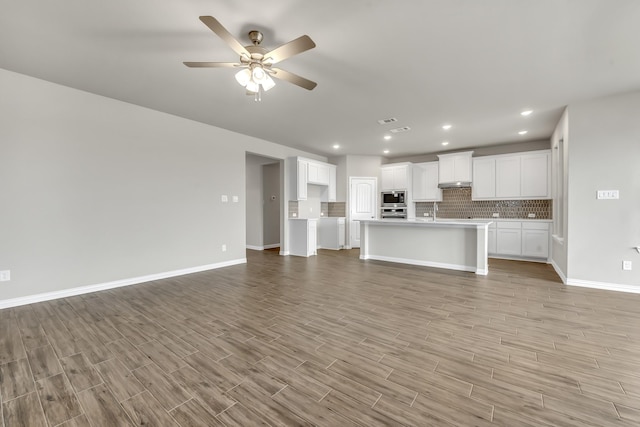 unfurnished living room featuring ceiling fan