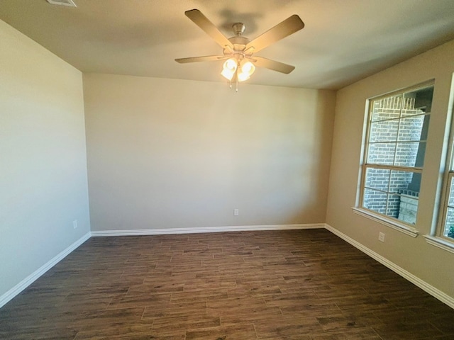 empty room with ceiling fan and dark hardwood / wood-style flooring