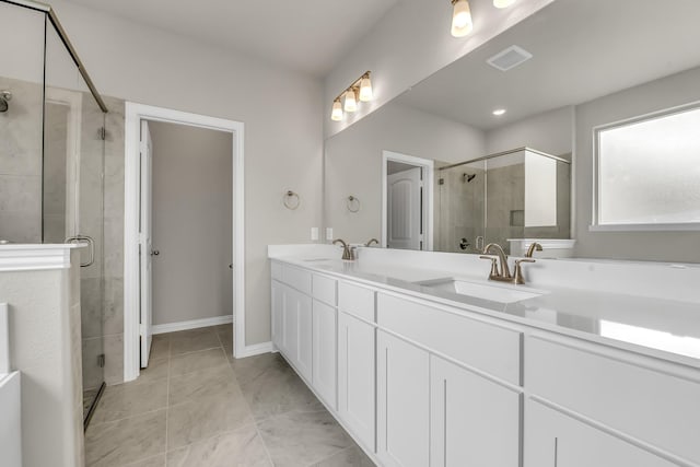 bathroom with a shower with shower door, vanity, and tile patterned floors