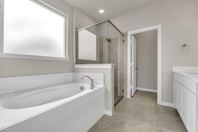 bathroom with tile patterned floors, plus walk in shower, vanity, and a healthy amount of sunlight