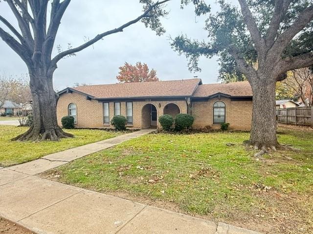 single story home with brick siding, a front yard, and fence