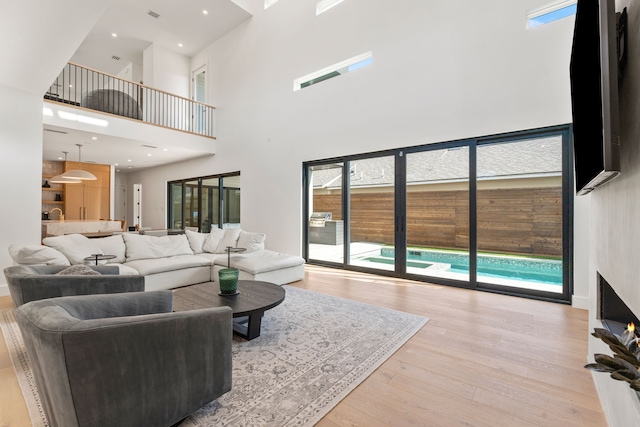 living room with light hardwood / wood-style floors and a high ceiling