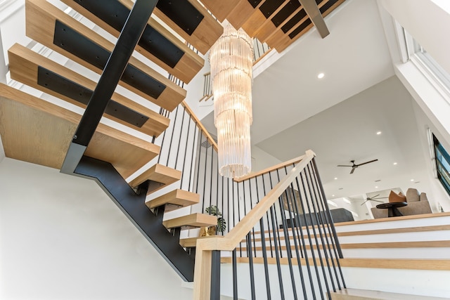 stairway with ceiling fan with notable chandelier