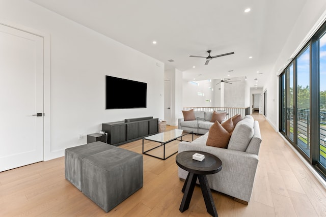 living room featuring ceiling fan and light hardwood / wood-style flooring